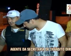 Agente de Trânsito, sendo conduzido por policial (Imagem TV Alterosa)
